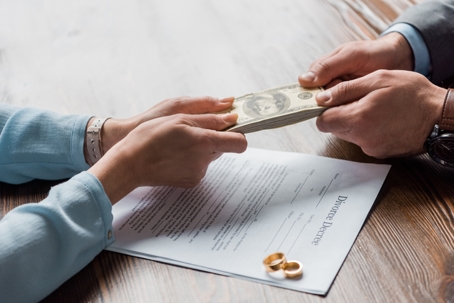 couple exchanging money after signing divorce decree