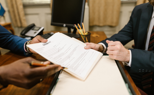 lawyer and client signing papers